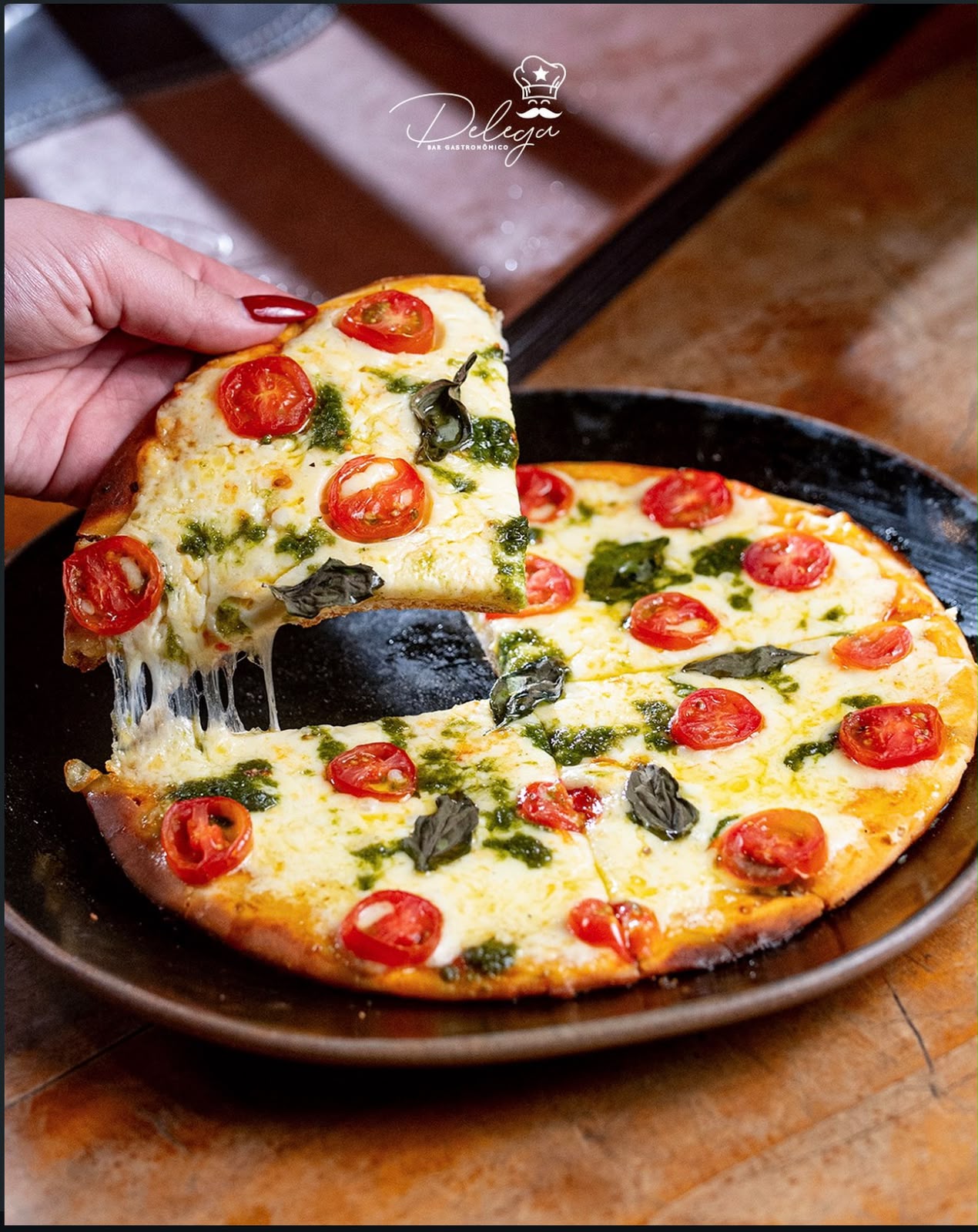 Pizza de massa fina com tomate-cereja, muçarela, pesto e manjericão